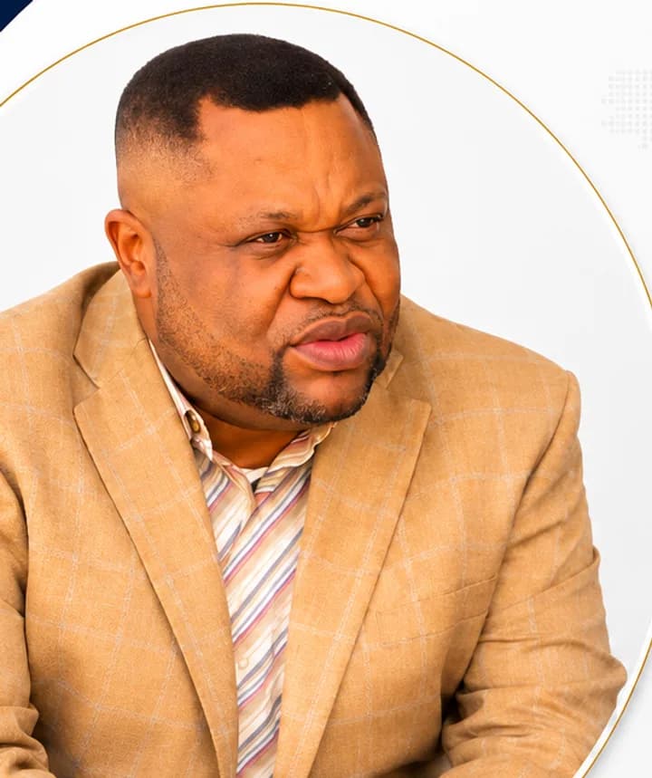 Portrait de Bakadisuila Shabana, Administrateur Gérant, en veste à carreaux beige.